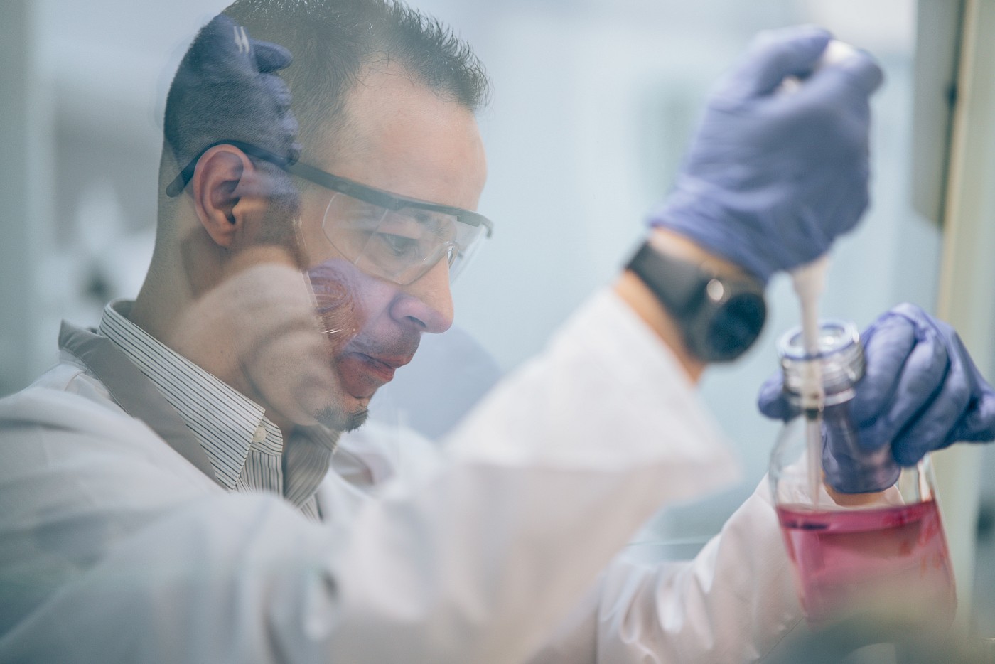 lab technician transferring liquid into a bottle
